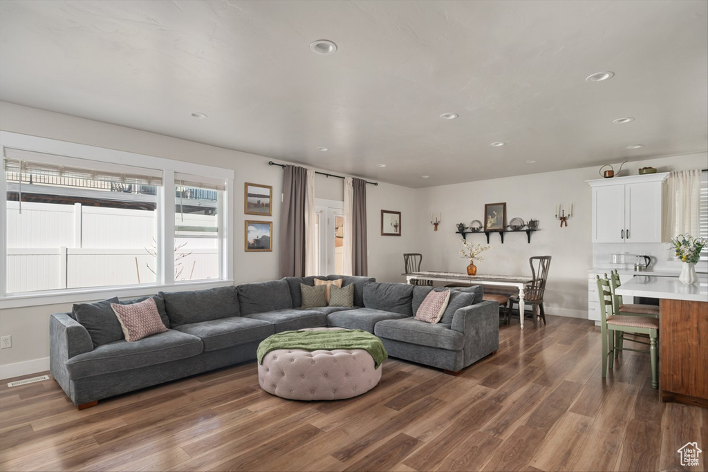Living area with recessed lighting, dark wood-style floors, and baseboards