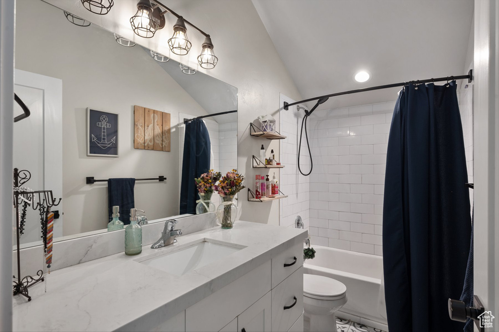 Bathroom with toilet, shower / tub combo, vanity, and lofted ceiling