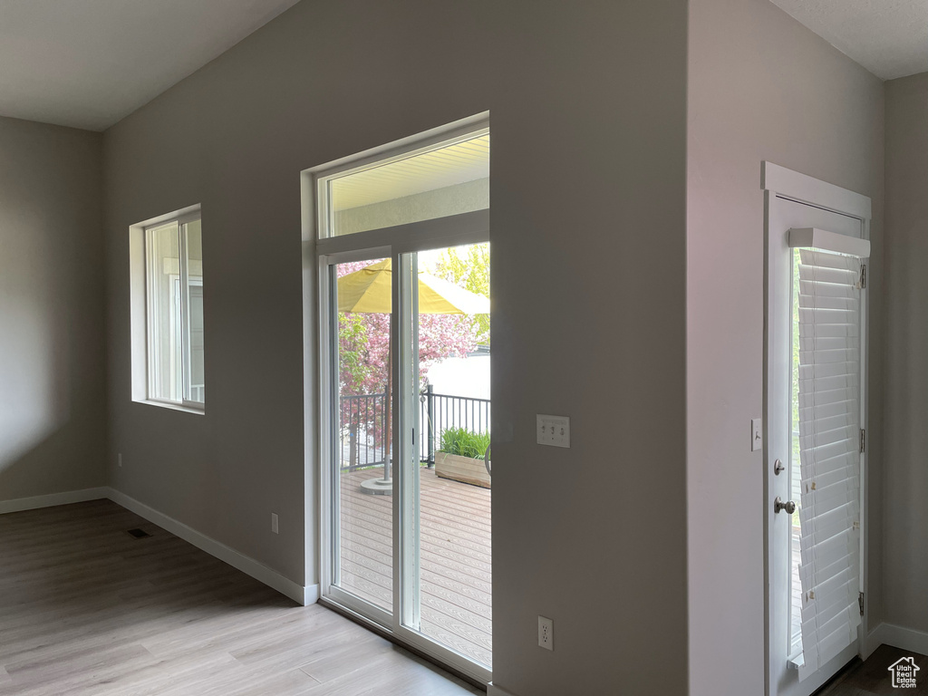 Doorway with baseboards and light wood finished floors