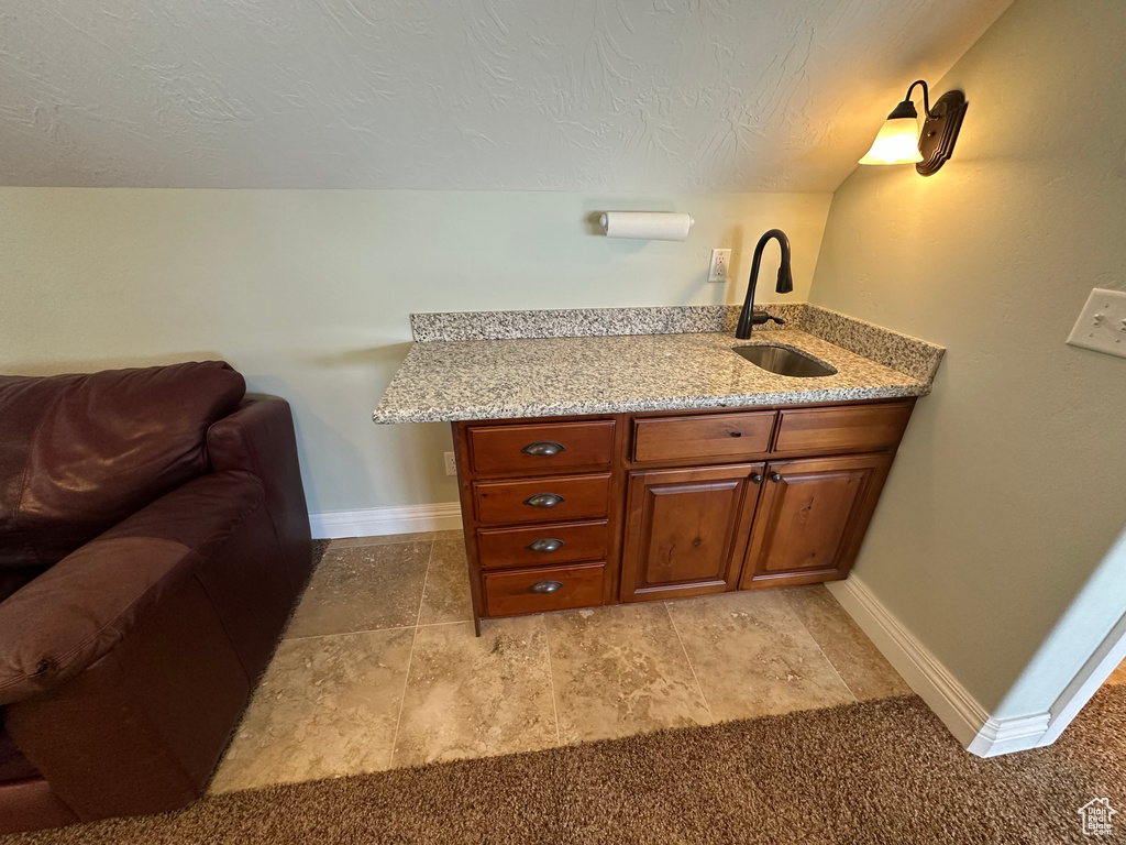 Interior space with vanity, a textured ceiling, and baseboards