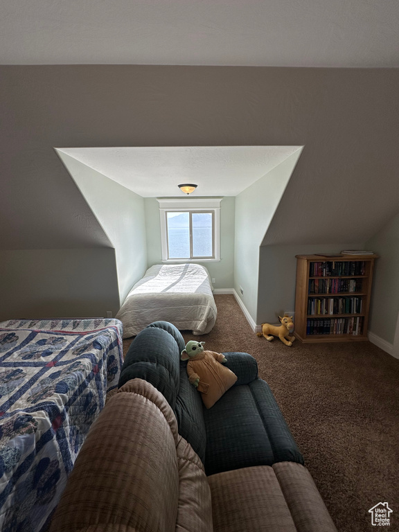 Bedroom with carpet flooring, baseboards, and vaulted ceiling