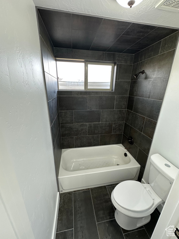Full bathroom featuring toilet, shower / bathtub combination, and visible vents