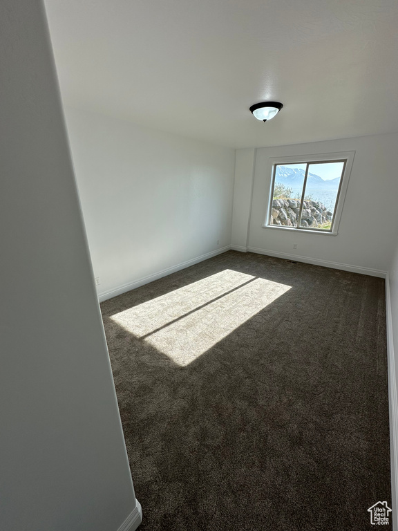 Carpeted spare room with baseboards