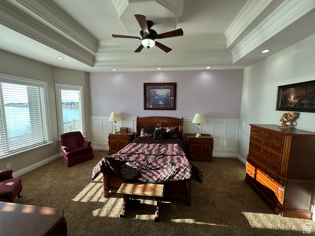 Bedroom with wainscoting, carpet floors, ornamental molding, and a raised ceiling