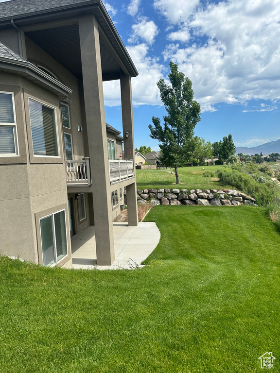View of yard with a patio and a balcony