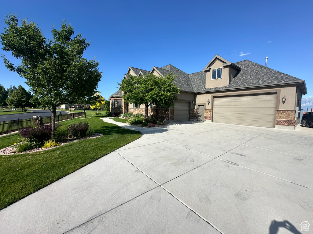 View of front of house featuring a garage, fence, concrete driveway, a front lawn, and stucco siding