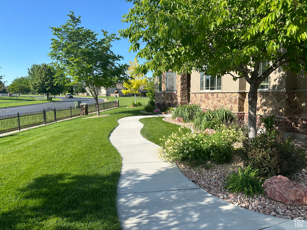View of community featuring fence and a lawn