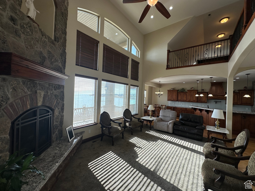Living area with a fireplace, baseboards, a ceiling fan, and a healthy amount of sunlight