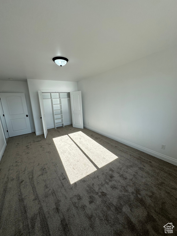 Unfurnished bedroom with a closet, baseboards, and carpet flooring