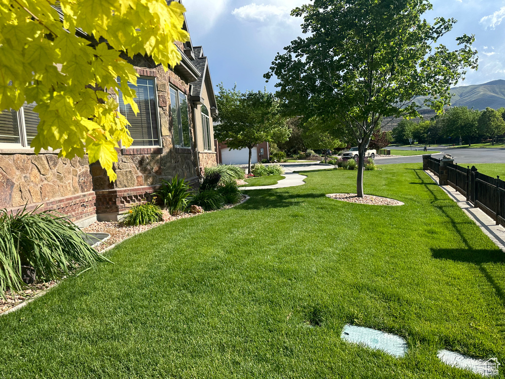 View of yard featuring a mountain view and fence