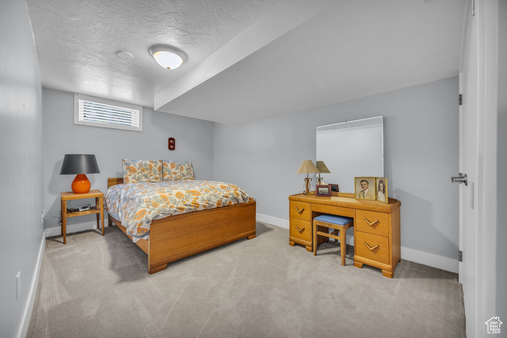Bedroom featuring a textured ceiling, baseboards, and carpet floors