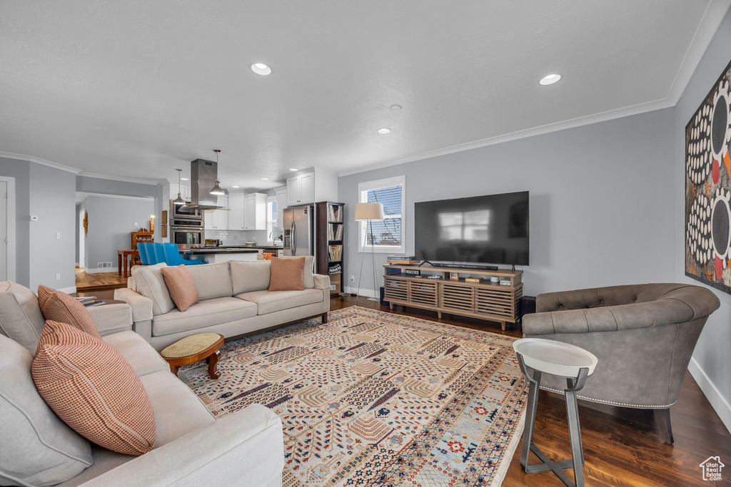 Living area featuring crown molding, baseboards, recessed lighting, and dark wood finished floors