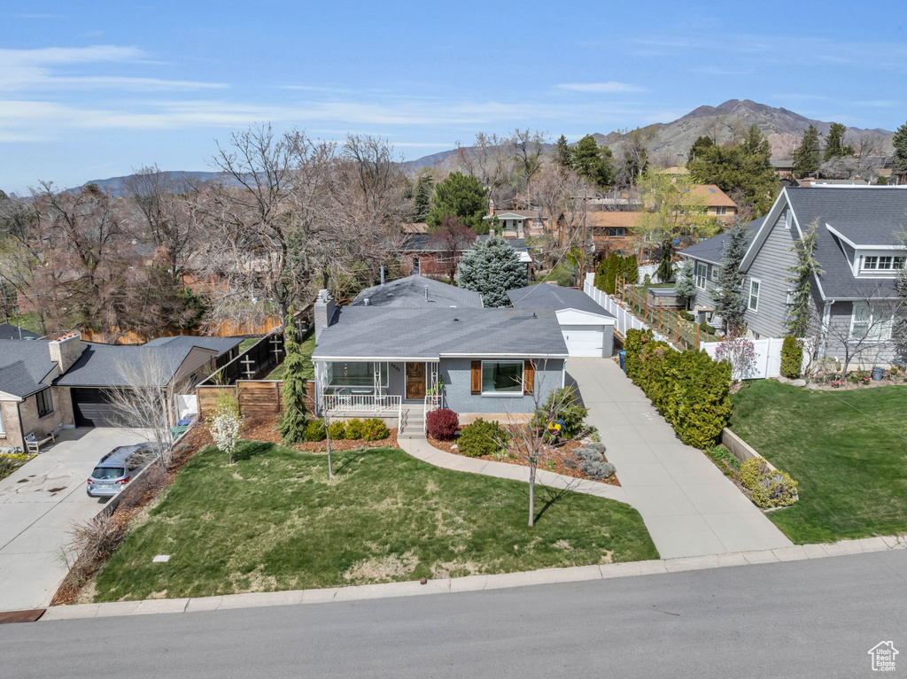 View of front of home with a front yard, a mountain view, a residential view, and covered porch