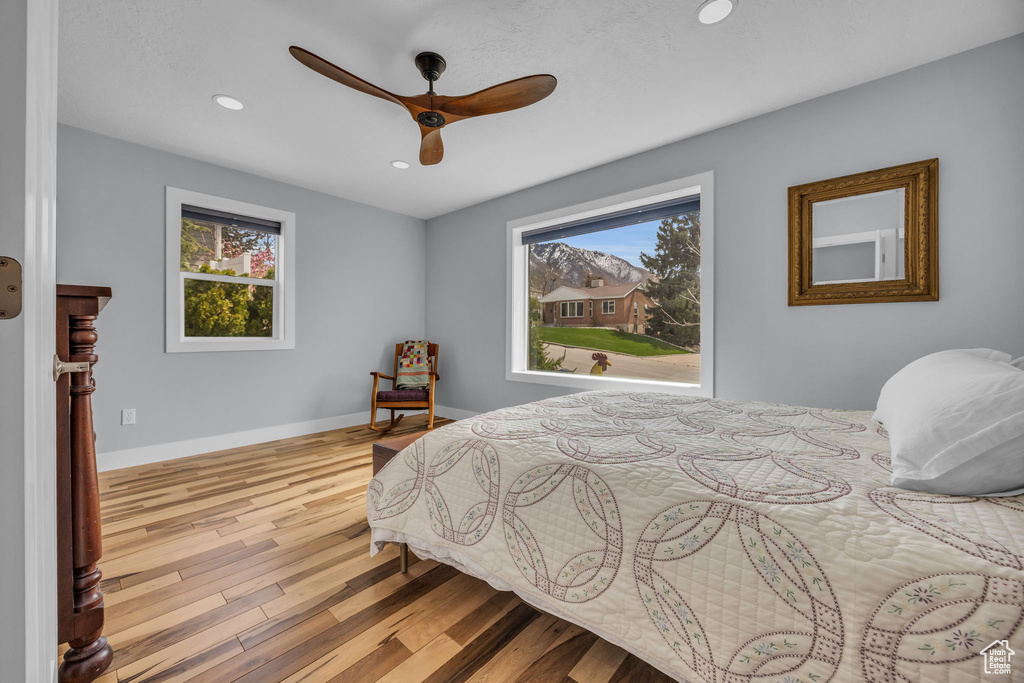 Bedroom featuring wood finished floors, baseboards, multiple windows, and recessed lighting