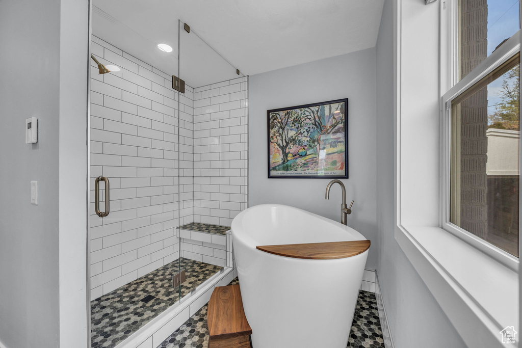 Full bathroom with a shower stall, a freestanding bath, and baseboards