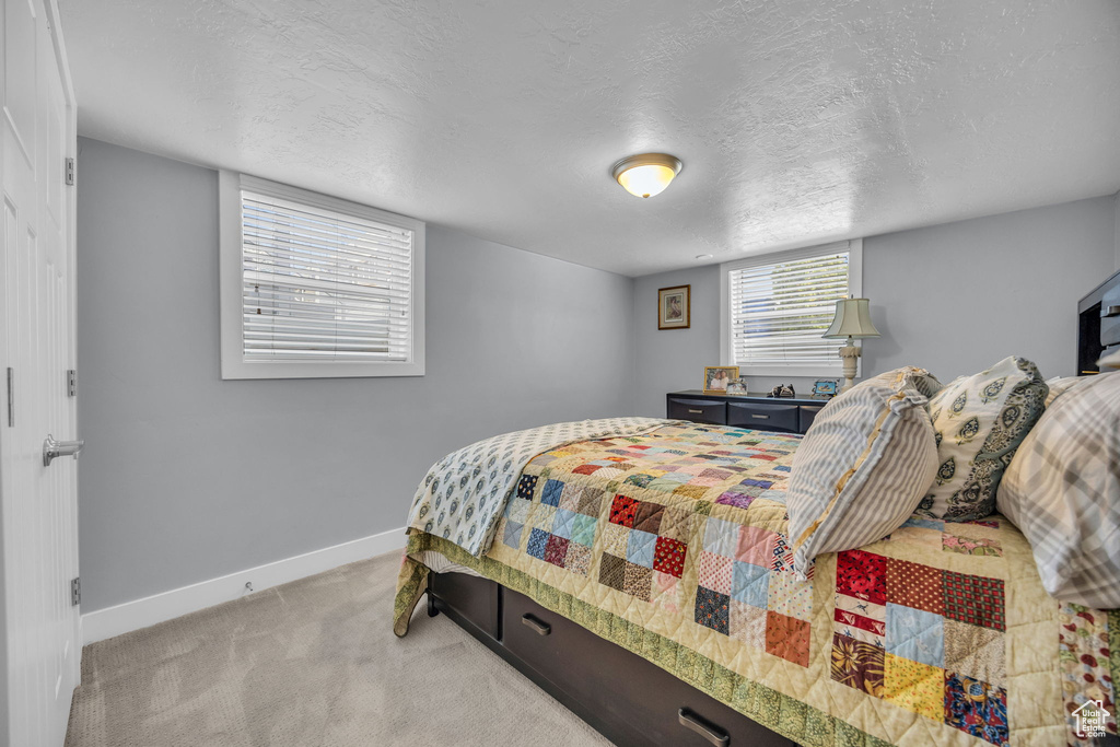 Carpeted bedroom with baseboards and a textured ceiling