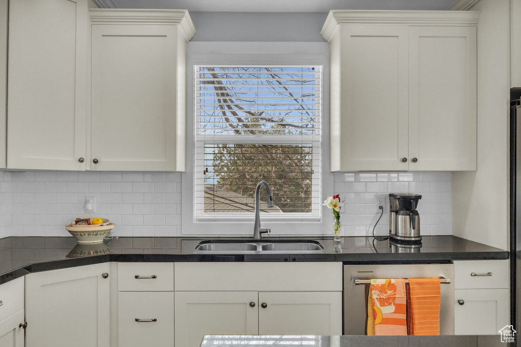 Kitchen with a sink, white cabinetry, and dishwasher
