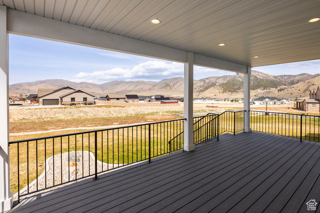 Wooden terrace featuring a mountain view and a yard