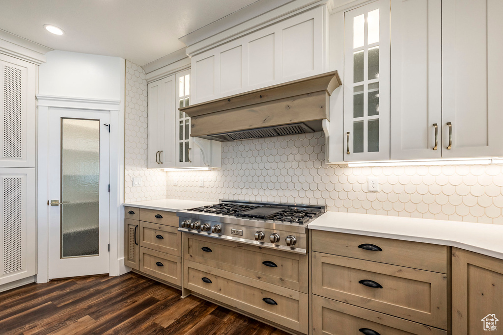 Kitchen with stainless steel gas stovetop, light countertops, glass insert cabinets, and recessed lighting