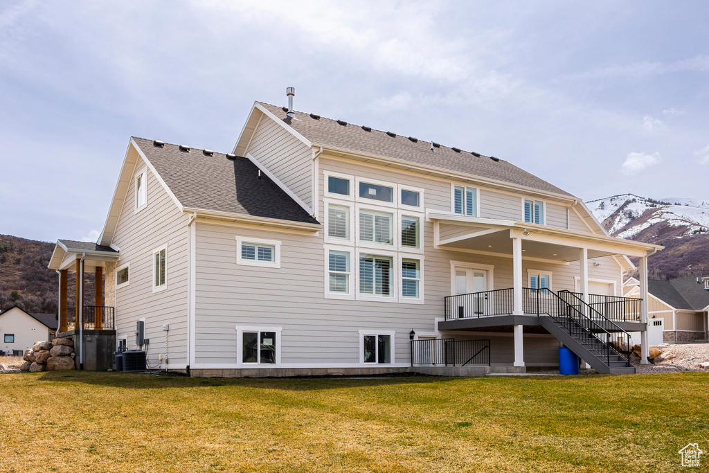Back of house with a lawn and stairs