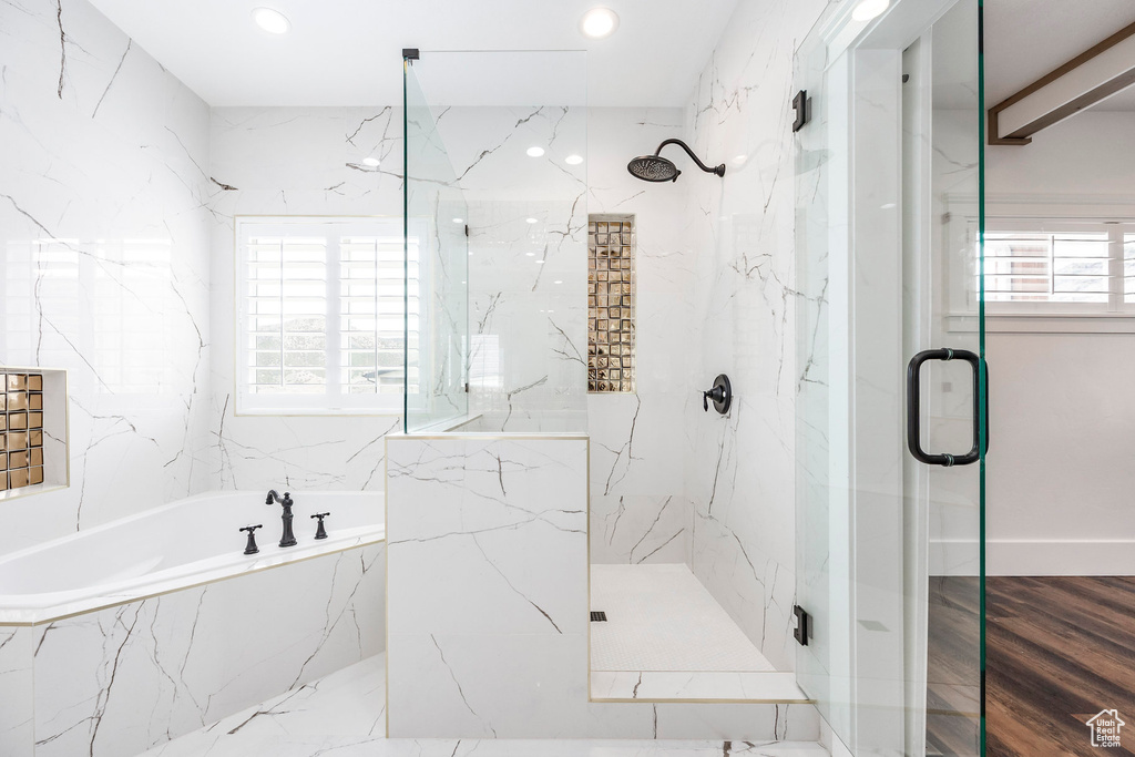Bathroom with a marble finish shower, a bath, and recessed lighting