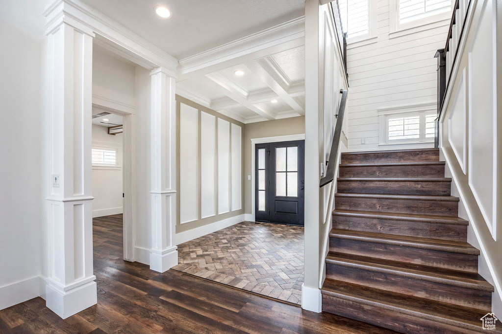 Entrance foyer with ornate columns, stairway, recessed lighting, coffered ceiling, and beam ceiling