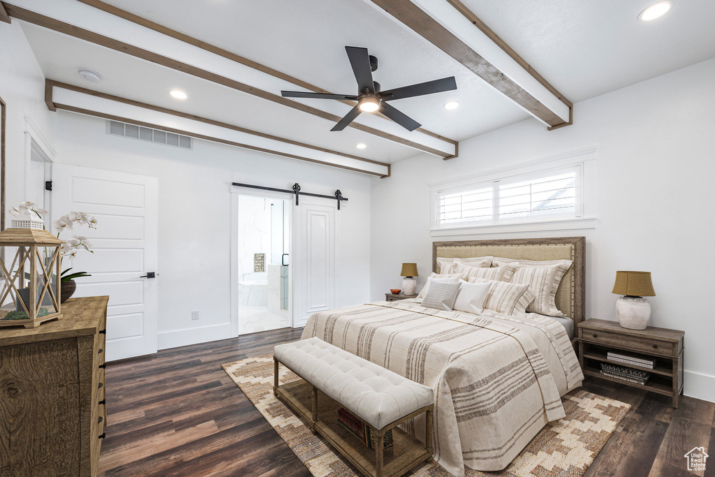 Bedroom featuring a barn door, beam ceiling, dark wood-type flooring, recessed lighting, and ensuite bath