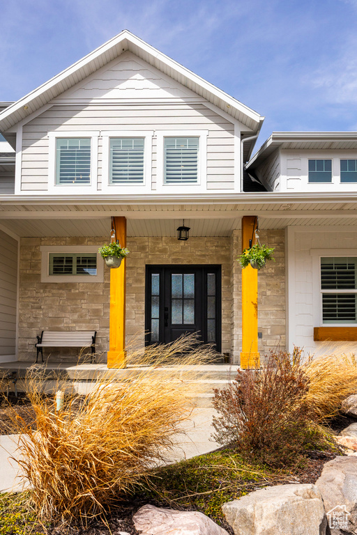 Doorway to property featuring a porch and stone siding