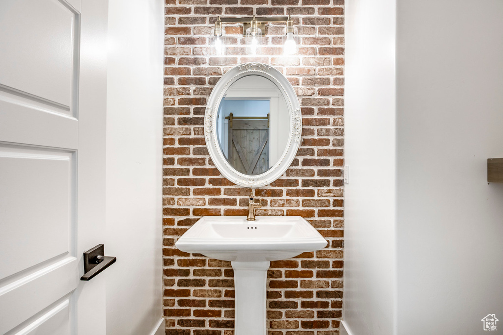 Bathroom featuring brick wall