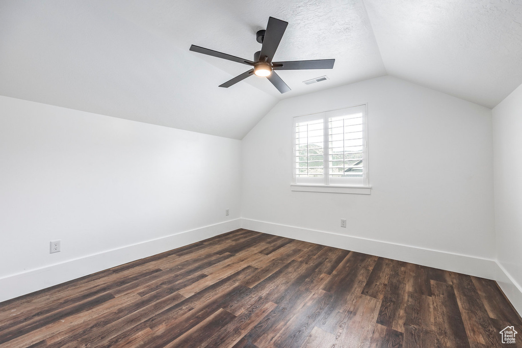 Additional living space featuring lofted ceiling, dark wood finished floors, and ceiling fan