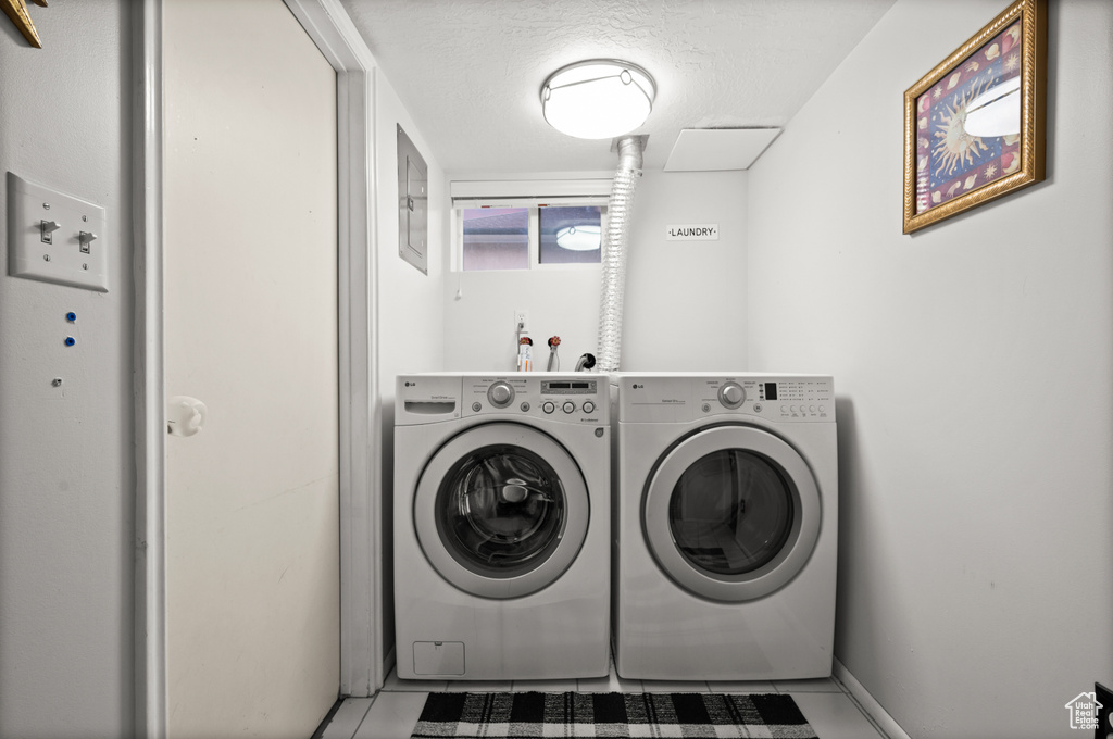 Laundry area with independent washer and dryer, baseboards, laundry area, and a textured ceiling