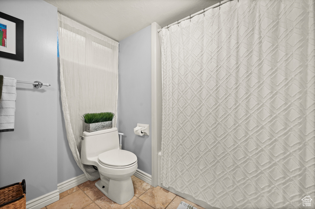 Bathroom featuring baseboards and toilet