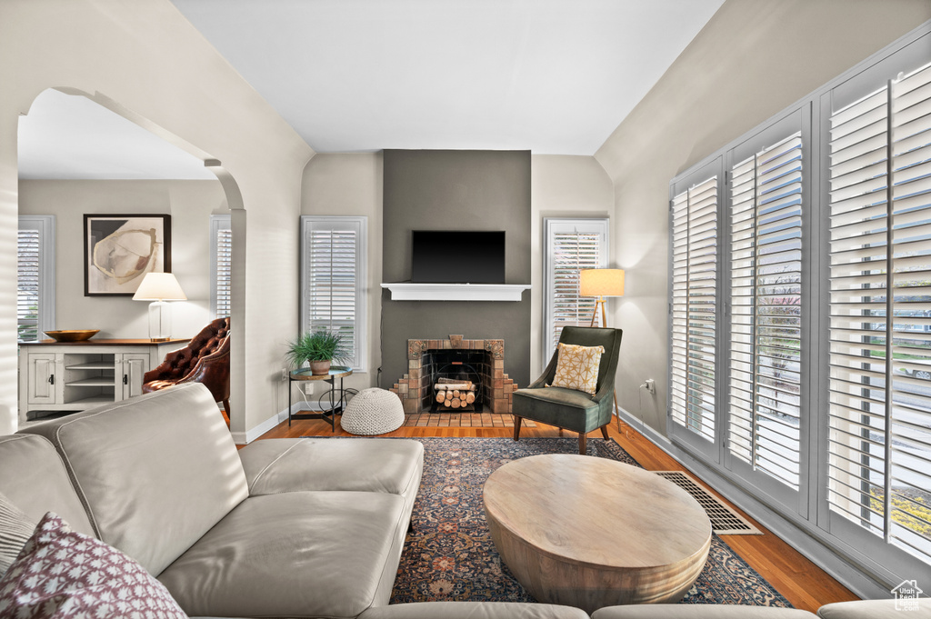 Living area featuring visible vents, baseboards, wood finished floors, and a fireplace with flush hearth