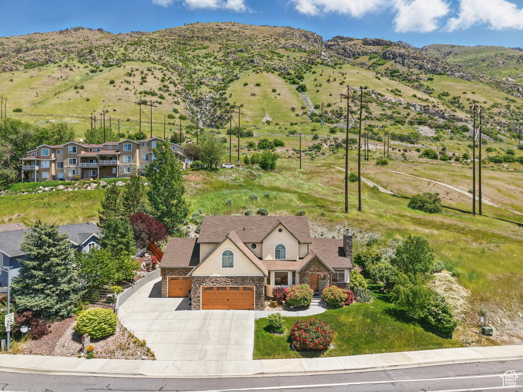 Aerial view of property and surrounding area featuring a mountainous background