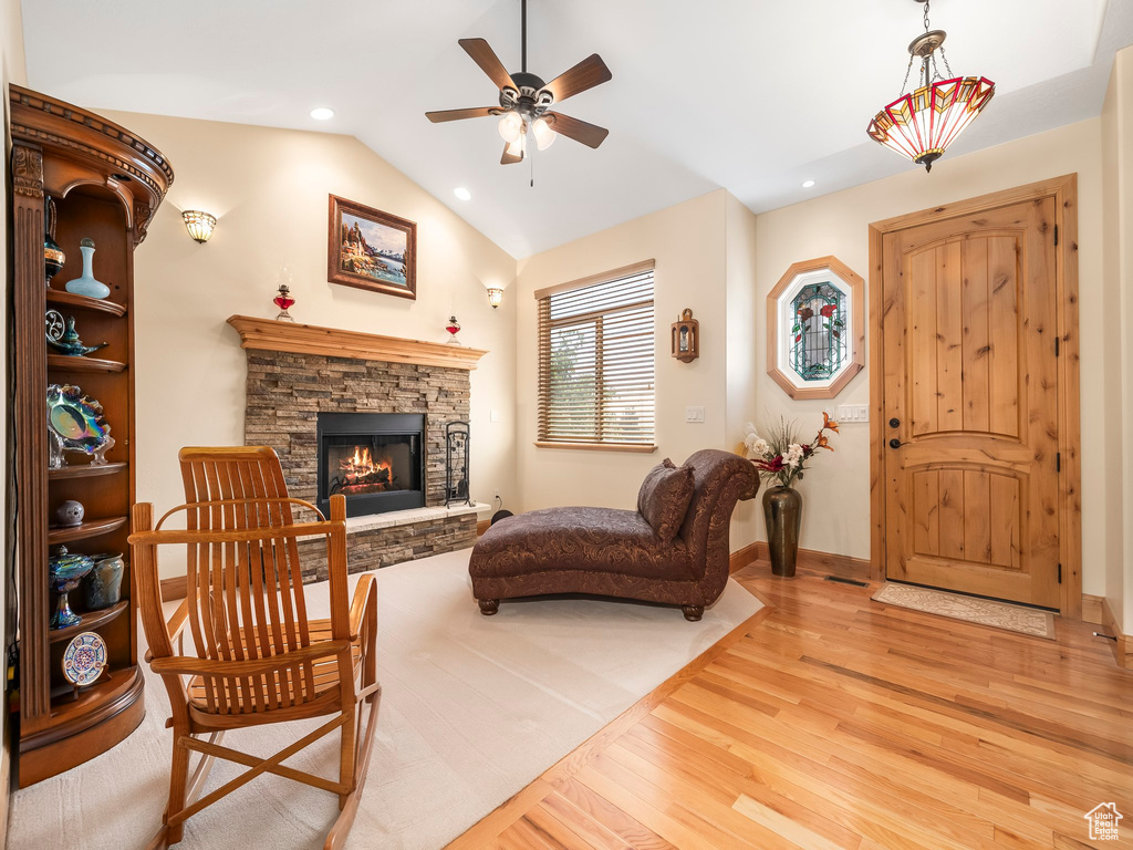 Living area with light wood-style floors, ceiling fan, a fireplace, vaulted ceiling, and recessed lighting