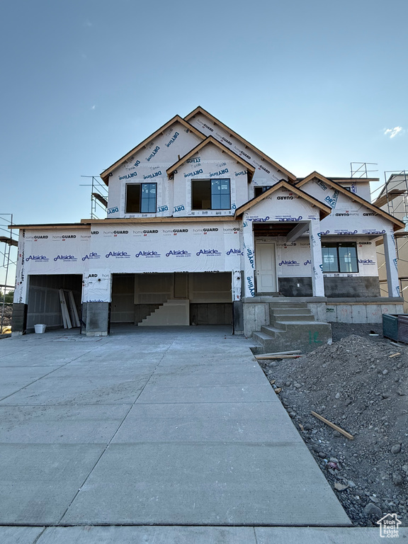 Property under construction featuring a garage and concrete driveway