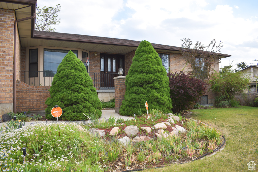 View of front of house with brick siding and a front yard