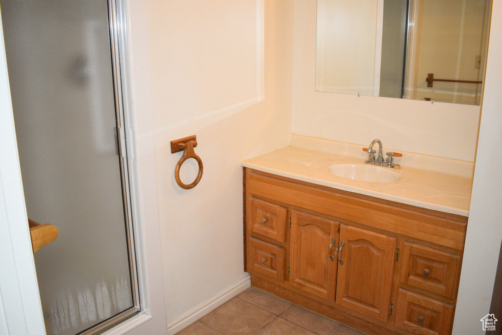 Bathroom with vanity, tile patterned floors, and a shower