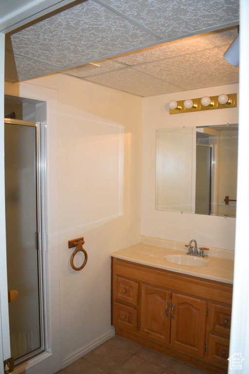 Full bath featuring a stall shower, vanity, and tile patterned flooring