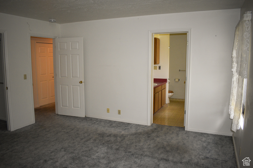 Unfurnished bedroom with carpet flooring and ensuite bathroom