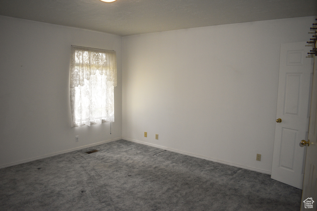 Carpeted spare room with baseboards