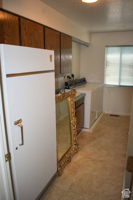Laundry room featuring independent washer and dryer and a textured ceiling