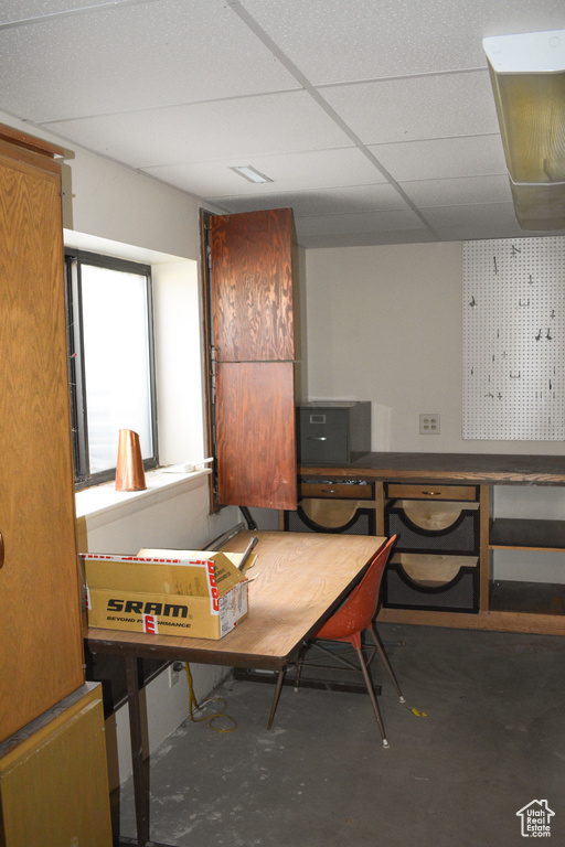 Misc room with unfinished concrete flooring and a paneled ceiling