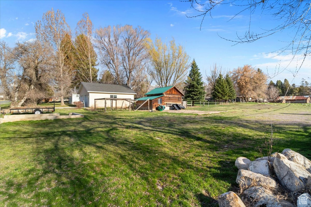 View of yard featuring an outdoor structure and fence