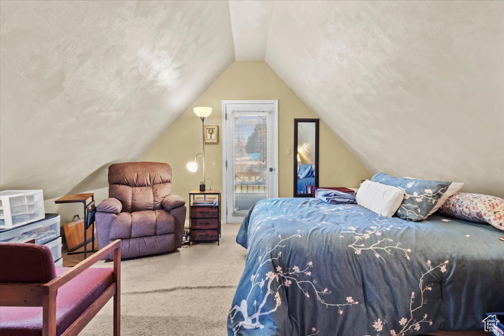 Bedroom with access to exterior, carpet, vaulted ceiling, and a textured ceiling