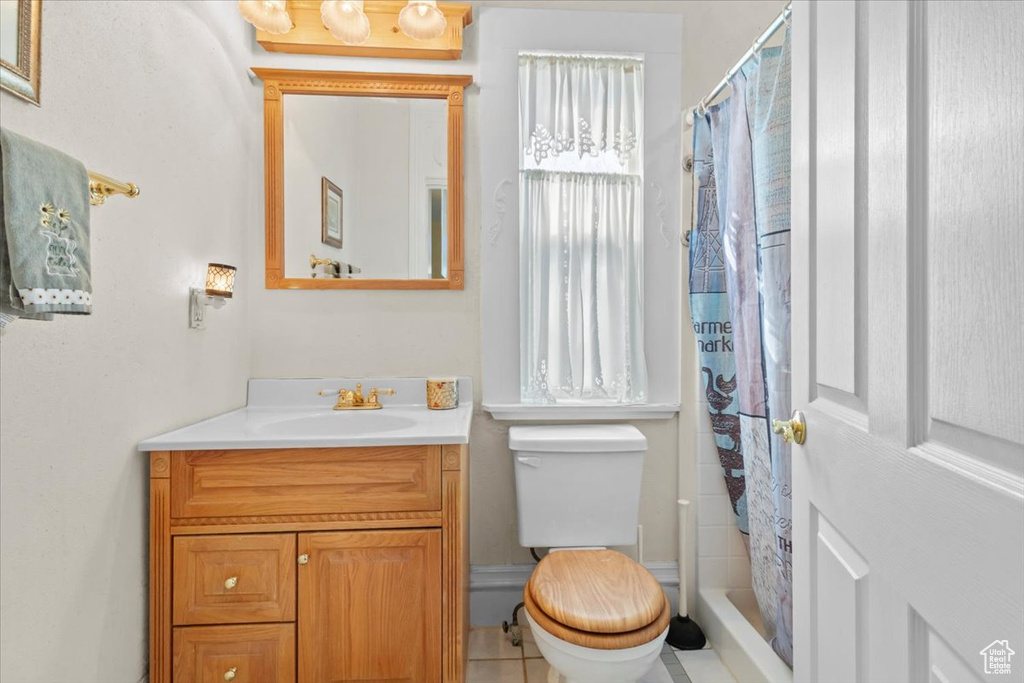 Bathroom with toilet, vanity, and a shower with curtain