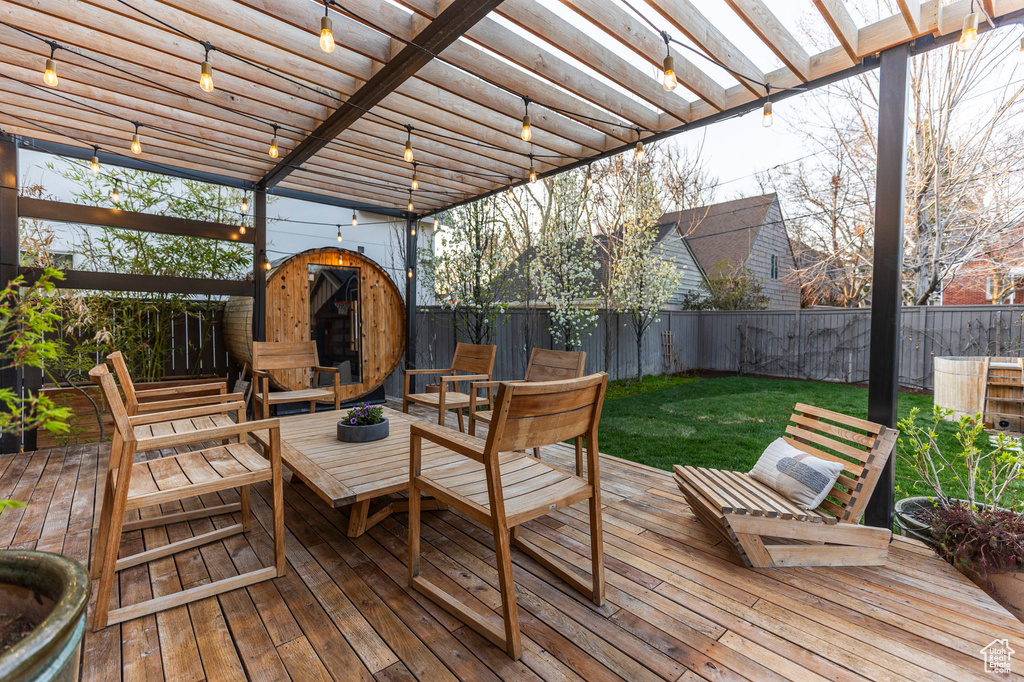 Deck featuring an outbuilding, a fenced backyard, a storage unit, a pergola, and outdoor lounge area