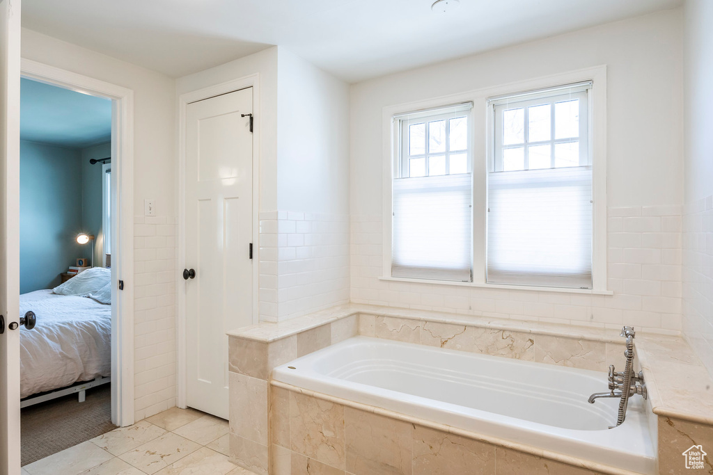 Bathroom featuring connected bathroom, tile patterned floors, and a bath