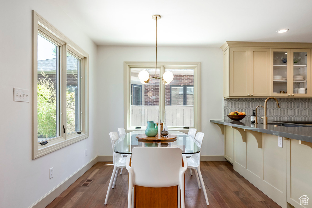 Dining area with healthy amount of natural light, a chandelier, wood finished floors, and recessed lighting