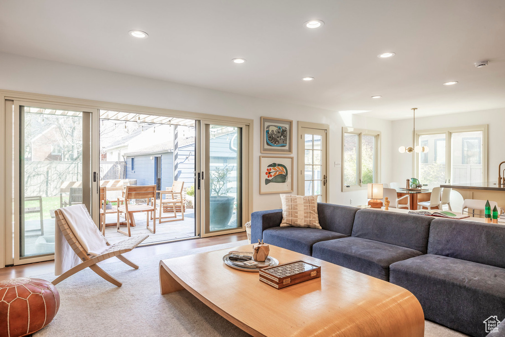 Living room with light colored carpet, recessed lighting, and a chandelier
